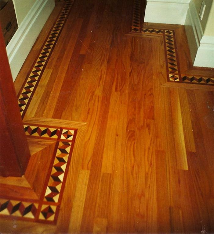 Solid wood floor installed with a decorative border after carpet removal, Oakland.